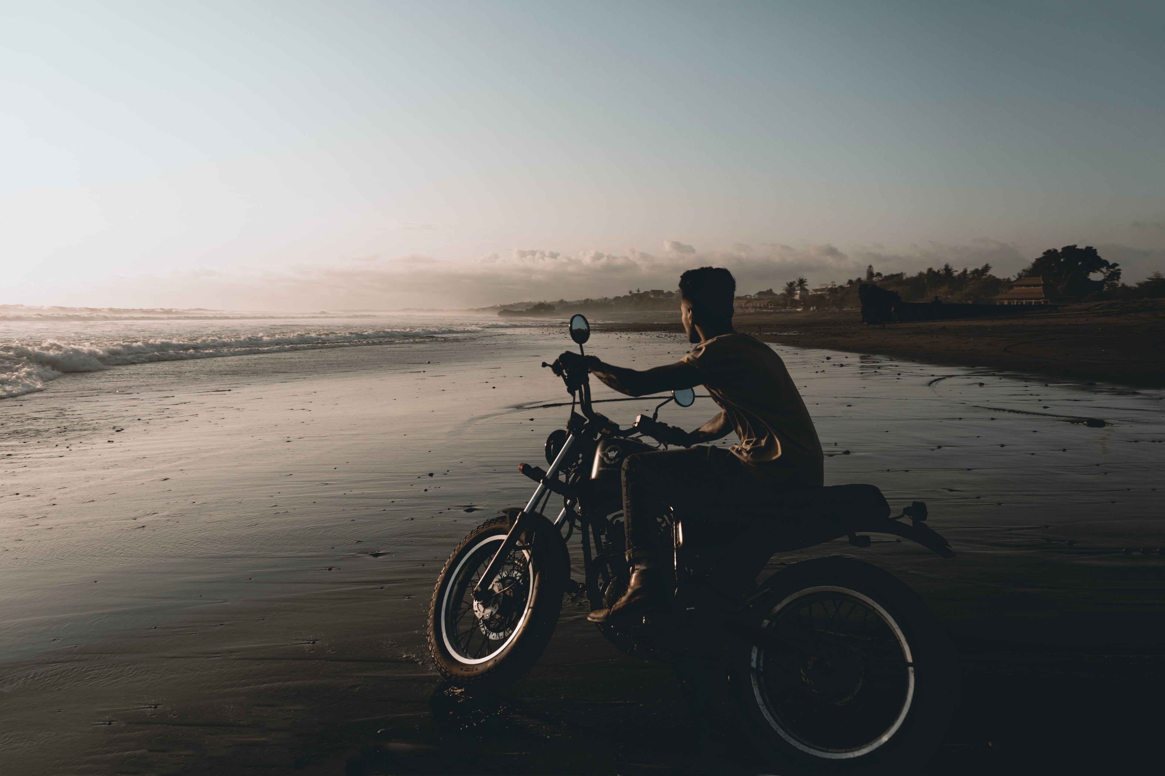motorcycle riding on the beach at dusk